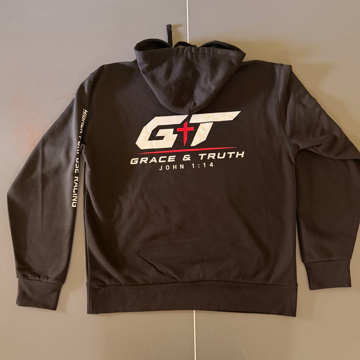 Back of the black Team Grace & Truth hoodie with the white and red GT mark