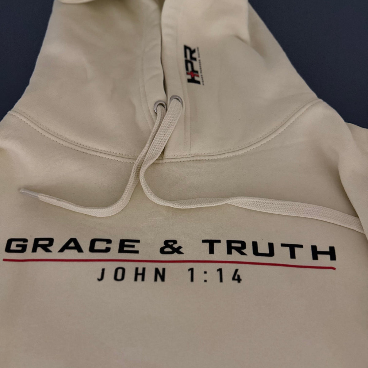 Close-up of the Grace & Truth chest print and HPR hood logo on the Vintage Pearl hoodie