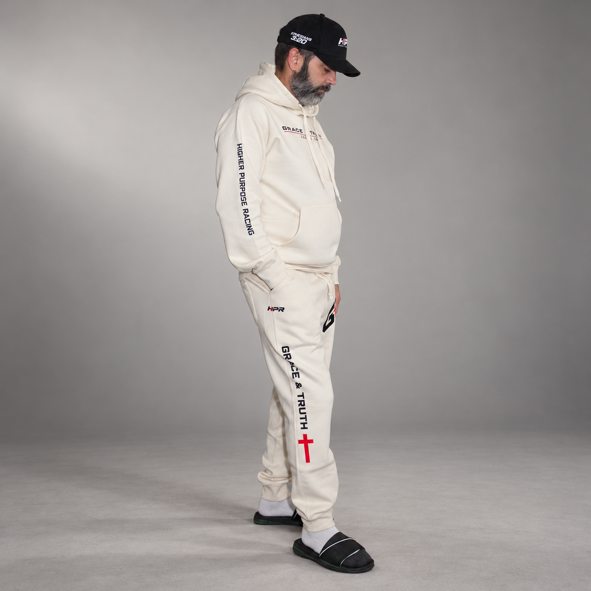 Side view of the Vintage Pearl Team Grace & Truth sweatsuit set with Higher Purpose Racing sleeve and Grace & Truth leg print