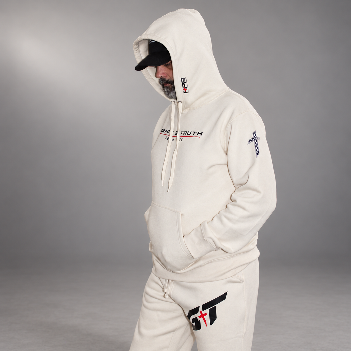 Man wearing the Vintage Pearl Team Grace & Truth hoodie with the hood up and matching sweatpants