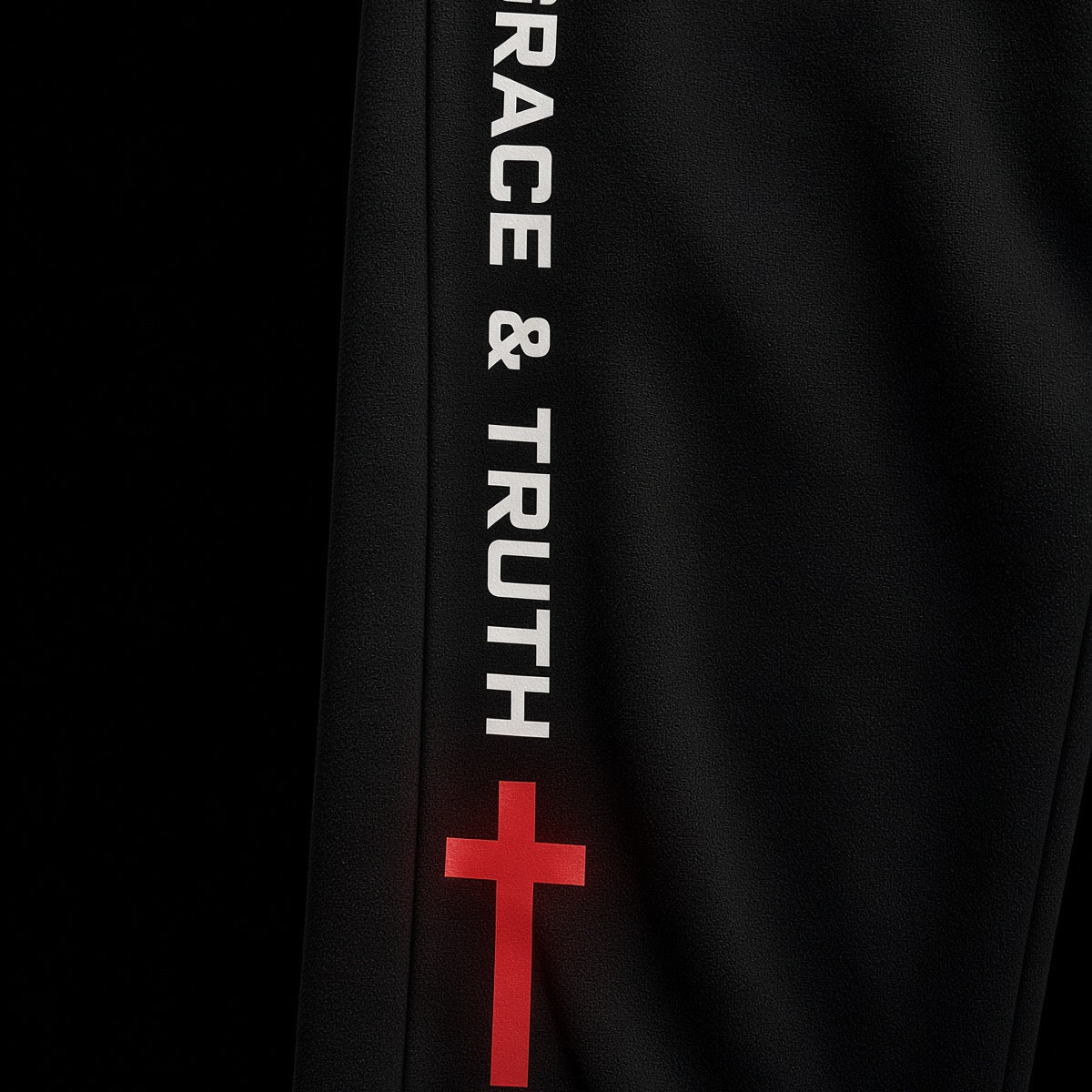Grace & Truth with red cross down the leg of the black sweatpants