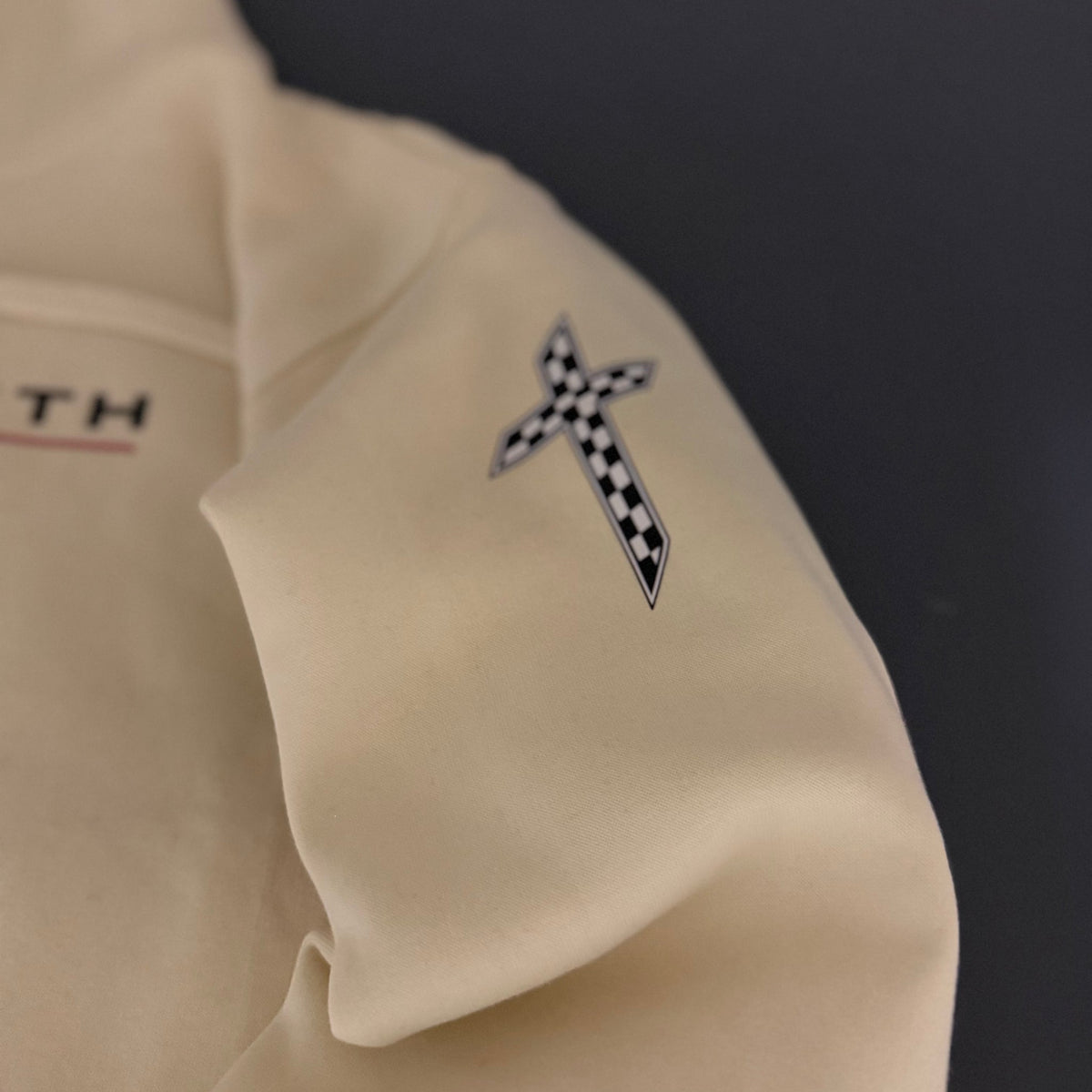 Checkered-flag cross printed on the sleeve of the Vintage Pearl hoodie