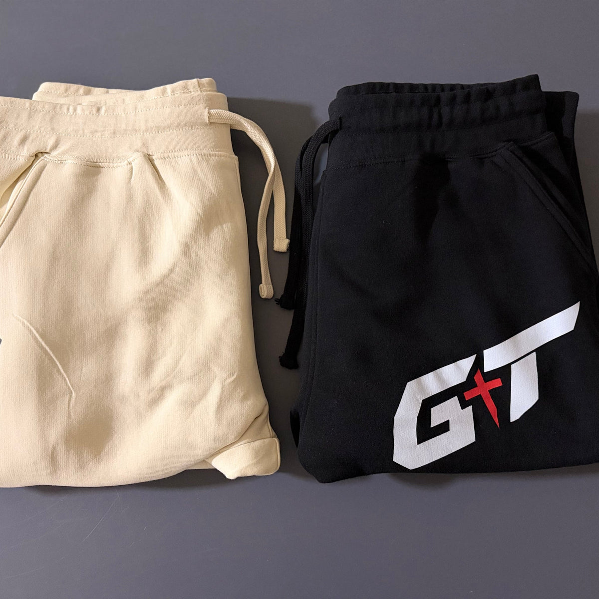 Vintage Pearl and black Team Grace & Truth sweatpants folded side by side