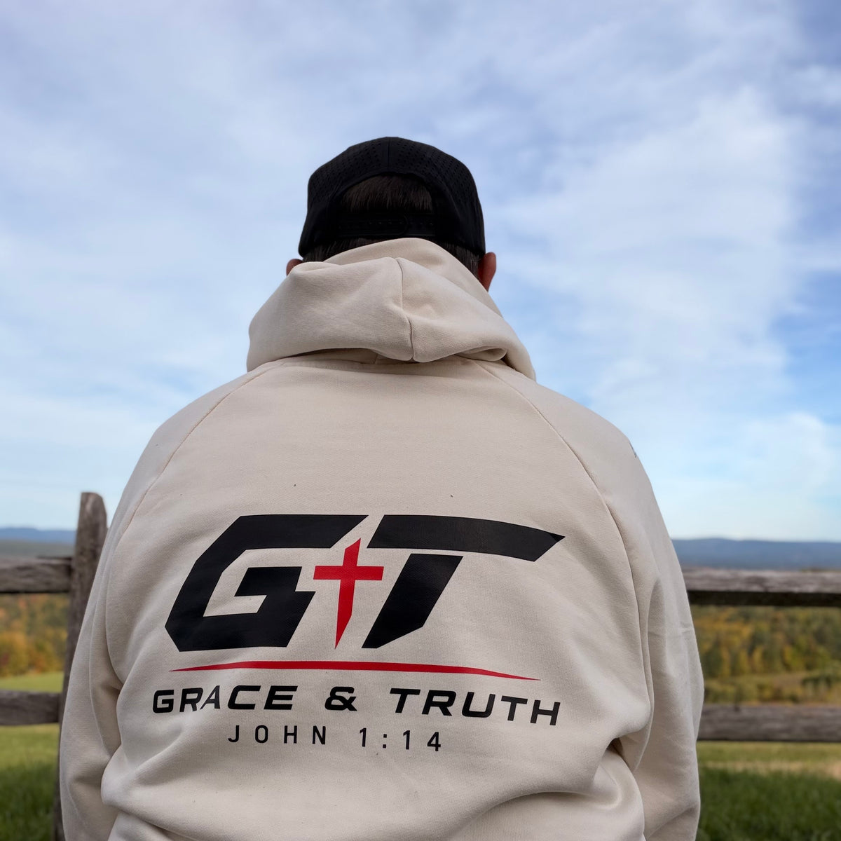 Back view of the Vintage Pearl Team Grace & Truth hoodie worn outdoors, GT mark on the back